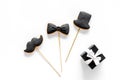 Happy Father`s day cards. Black tie, mustache and hat cookies and gift. White desk background top view mockup Royalty Free Stock Photo