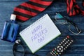 Happy father`s day. Text on a notebook and men`s tie, glasses and men`s accessories on a blue wooden table. men`s holiday. top Royalty Free Stock Photo