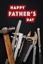 Happy father`s day text sign with many working tools on black ru Royalty Free Stock Photo