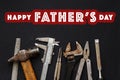 Happy father`s day text sign with many working tools on black ru