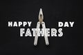 Happy father`s day text sign on working tools pliers on black ru Royalty Free Stock Photo