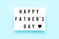 HAPPY FATHER`S DAY written in light box on blue background, greeting card. Fathers Day celebration concept