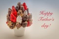 Happy Father`s greeting card with red lettering; A bundle of edible flowers, arrangement of strawberries covered with chocolate