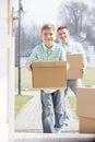 Happy father and son with cardboard boxes entering new home Royalty Free Stock Photo