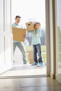 Happy father and son with cardboard boxes entering into new house Royalty Free Stock Photo