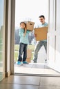 Happy father and son with cardboard boxes entering into new house Royalty Free Stock Photo