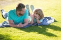 Happy father and son enjoying summer time laying on grass, vacation in a sunny park. Royalty Free Stock Photo