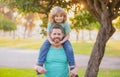 Happy father and son enjoying summer time on vacation in a sunny park. Dad carrying on shoulders happy little boy. Royalty Free Stock Photo