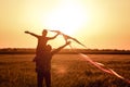 Happy father and son flying kite in the field at sunset Royalty Free Stock Photo