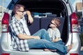 Happy father and son getting ready for road trip on a sunny day Royalty Free Stock Photo