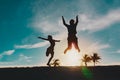Happy father and son jumping at sunset beach Royalty Free Stock Photo