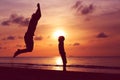 happy father and son jumping at sunset beach Royalty Free Stock Photo