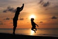 happy father and son jumping at sunset beach Royalty Free Stock Photo