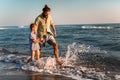 Father and son, man & boy child, running and having fun in the sand and waves of a sunny beach Royalty Free Stock Photo