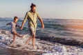 Father and son, man & boy child, running and having fun in the sand and waves of a sunny beach Royalty Free Stock Photo