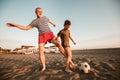 Father And Son Play Football On The Beach Having Great Family Time On Summer Holidays
