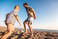 Father And Son Play Soccer Or Football On The Beach Having Great Family Time On Summer Holidays