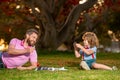 Happy father and son playing chess lying on grass at lawn park. Fathers Day and parenthood concept. Royalty Free Stock Photo