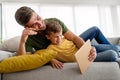 Happy father and son playing with digital tablet at home Royalty Free Stock Photo