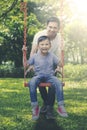 Happy father and son playing with a swing at park Royalty Free Stock Photo