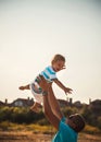 Happy father and son playing together at beach. Father throwing his son in the air