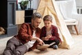 Happy father and son reading book at home together Royalty Free Stock Photo