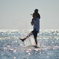 Happy father and son on seashore beach having fun water splash