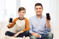 Happy father and son with smartphones at home Royalty Free Stock Photo