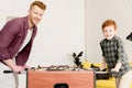 happy father and son smiling at camera while playing table football together Royalty Free Stock Photo