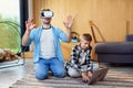 Happy young father and son testing virtual reality headset playing augmented video reality games.