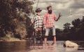 Happy father and son together fishing in summer day under beautiful sky on the river. Fly fishing. Fly fisherman using Royalty Free Stock Photo
