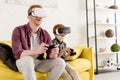 happy father and son in virtual reality headsets playing with joysticks Royalty Free Stock Photo