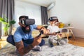 Father and son in virtual reality headsets playing with joysticks at home Royalty Free Stock Photo