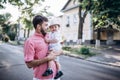 Happy father and son walk in old city street. City road with old bulding and green trees on the background Royalty Free Stock Photo