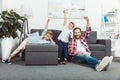 happy father with sons raising hands and eating popcorn