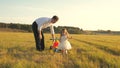 Happy father teaches little daughter to ride a bike. Dad plays with small child on lawn. kid learns to ride bicycle Royalty Free Stock Photo