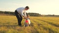 Happy father teaches little daughter to ride a bike. Dad plays with small child on lawn. kid learns to ride bicycle Royalty Free Stock Photo