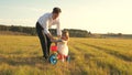 Happy father teaches little daughter to ride a bike. Dad plays with small child on lawn. kid learns to ride bicycle Royalty Free Stock Photo