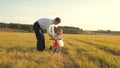 Happy father teaches little daughter to ride a bike. Dad plays with small child on lawn. kid learns to ride bicycle Royalty Free Stock Photo