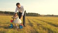 Happy father teaches little daughter to ride a bike. Dad plays with small child on lawn. kid learns to ride bicycle Royalty Free Stock Photo