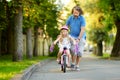 Happy father teaching his little daughter to ride a bicycle. Child learning to ride a bike. Royalty Free Stock Photo