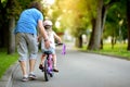 Happy father teaching his little daughter to ride a bicycle. Child learning to ride a bike. Royalty Free Stock Photo