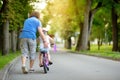 Happy father teaching his little daughter to ride a bicycle. Child learning to ride a bike. Royalty Free Stock Photo