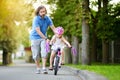 Happy father teaching his little daughter to ride a bicycle. Child learning to ride a bike. Royalty Free Stock Photo