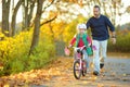 Happy father teaching his little daughter to ride a bicycle. Child learning to ride a bike. Royalty Free Stock Photo