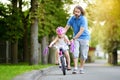 Happy father teaching his little daughter to ride a bicycle. Child learning to ride a bike.