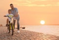 Happy father teaching his son to ride bicycle near river Royalty Free Stock Photo