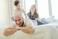 Happy father two kids having fun together on a bed Royalty Free Stock Photo