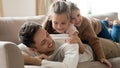 Happy father with two little daughters relaxing on couch Royalty Free Stock Photo