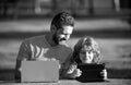 Happy father using laptop relax with schooler son holding laptop have fun together, smiling dad and little boy child